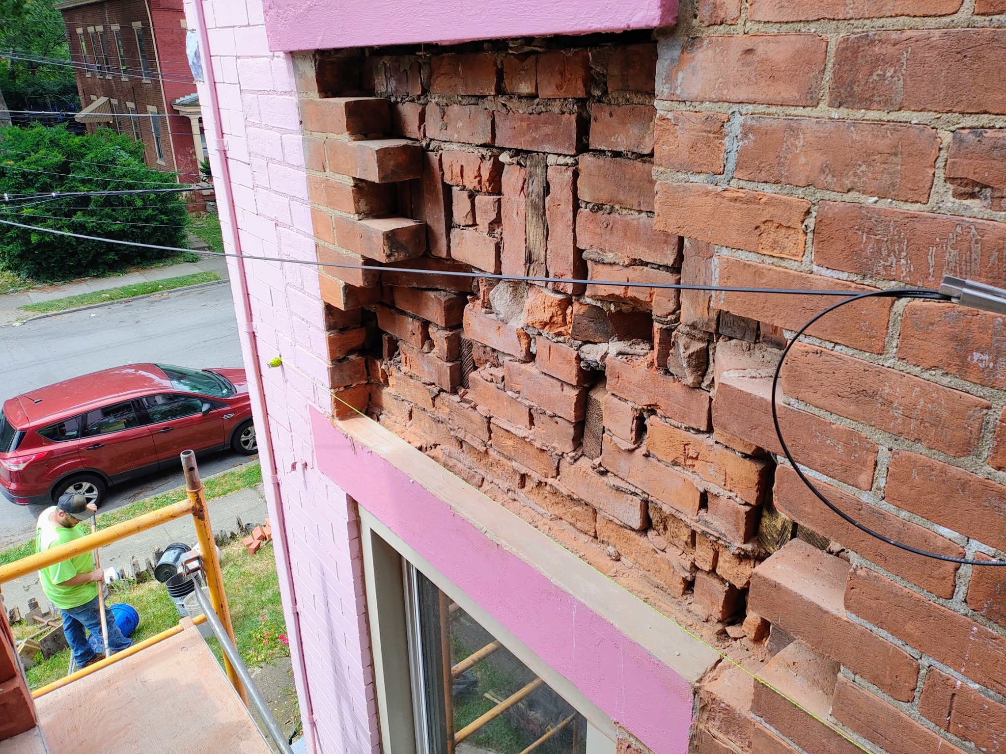 Deteriorated historic brick exposed above a window